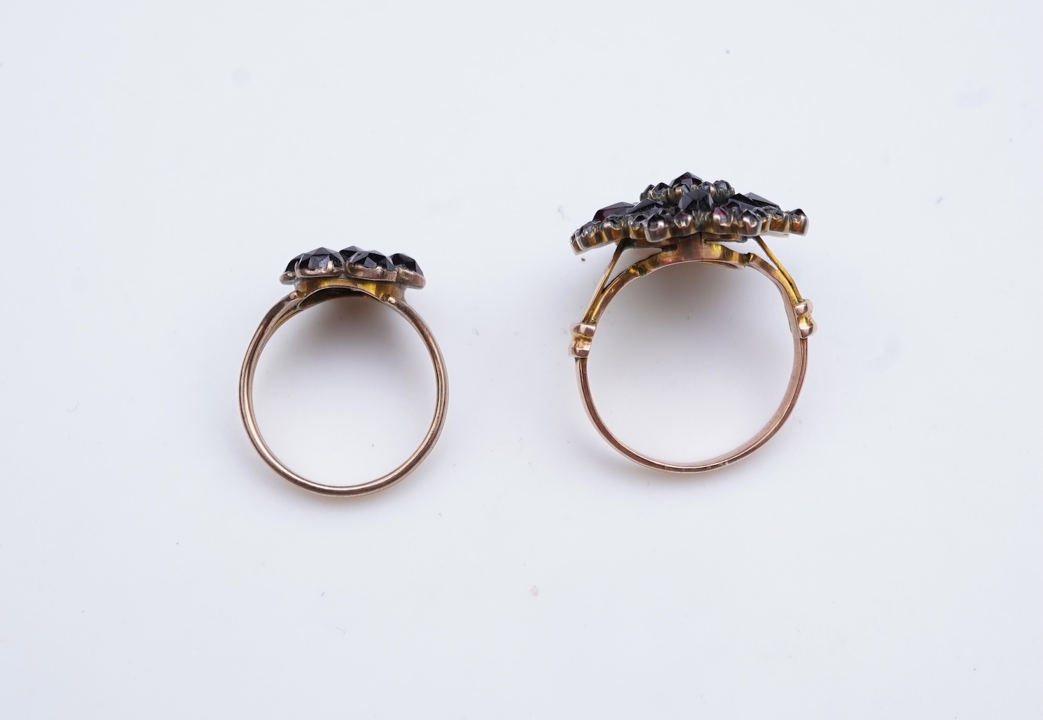 A suite of garnet and paste jewellery, comprising: a brooch, 5cm diameter; a bangle, inner circumference 16cm; two rings, sizes I and M; a pair of earrings, and a single earring, each set with rose-cut garnets; and a pai